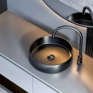Curved matte black mixer tap installed with round above-counter basin and modern vanity