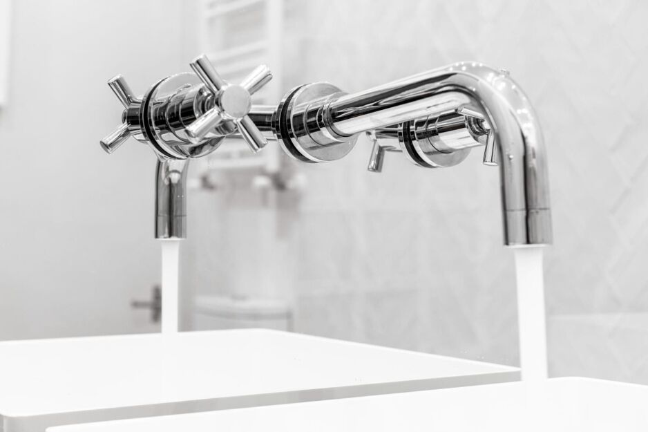 Close-up of modern chrome wall tapware installed above twin sinks in a bathroom