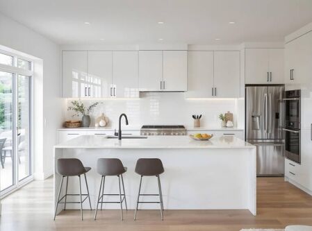 Modern white kitchen with sleek cabinetry and minimalist design, illustrating a practical kitchen cabinet buying guide for homeowners
