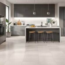 Modern kitchen with neutral-toned porcelain floor tiles, featuring a stylish island, dark cabinetry, and pendant lighting – best kitchen floor tiles for durability and design