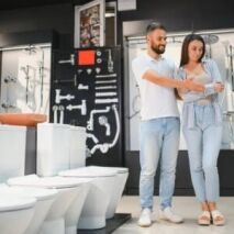 Couple browsing toilets and tapware in a modern Perth bathroom store, exploring fixtures and finishes for their renovation project