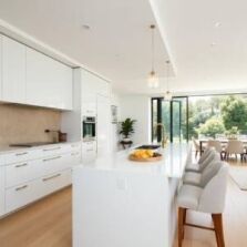 Modern white kitchen showcasing flat pack style cabinetry with island and seating