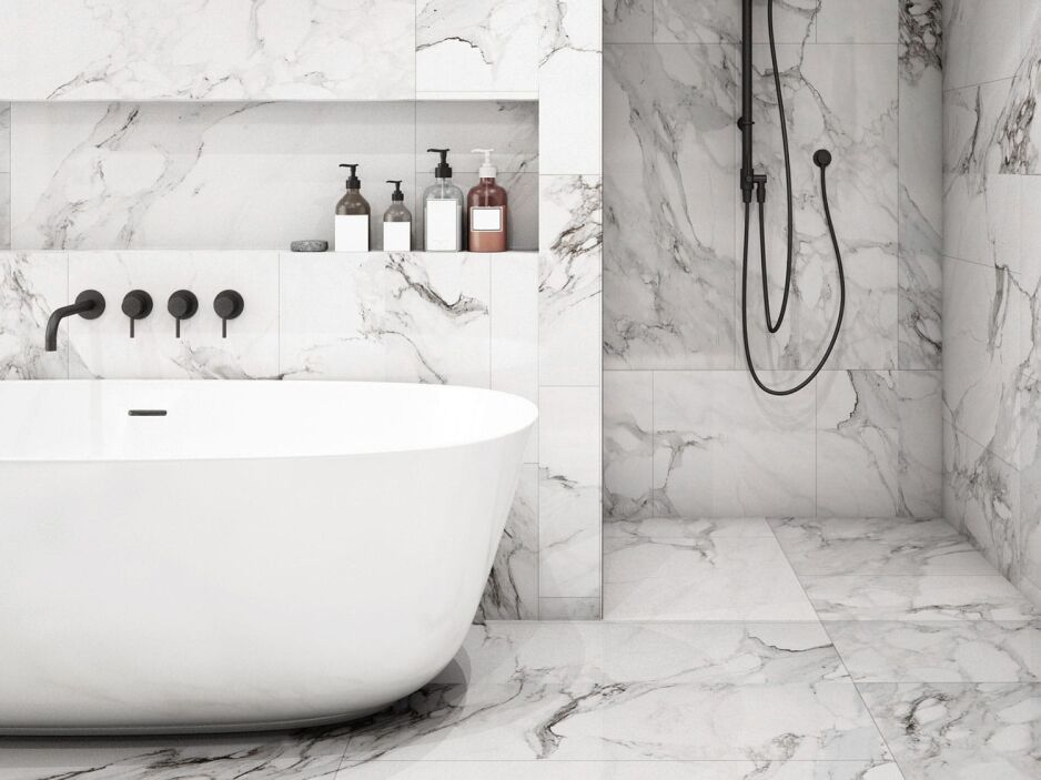 Luxurious marble bathroom with black wall-mounted 3 peice mixer tap set over bath