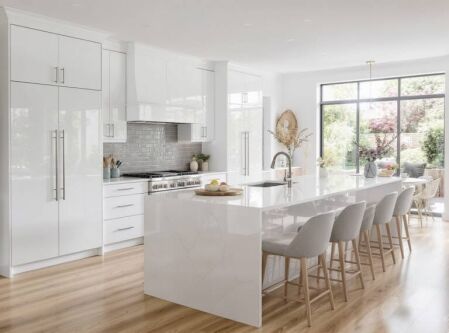 Bright modern white kitchen with stainless steel cabinet handles, marble-look island benchtop, and light timber flooring in Perth home