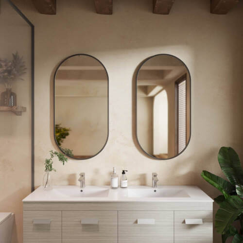 A pair of Como gunmetal oval mirrors in a modern bathroom setting