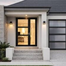 Black aluminium front entry door with glass panels in a modern rendered home