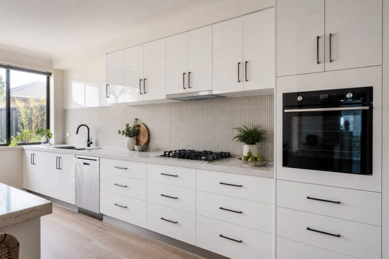 A modern Perth kitchen with high-gloss white cabinets, black handles, a stone-look benchtop and matte black tapware