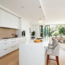 Modern white kitchen showcasing flat pack style cabinetry with island and seating