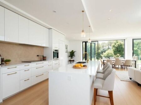 Modern white kitchen showcasing flat pack style cabinetry with island and seating