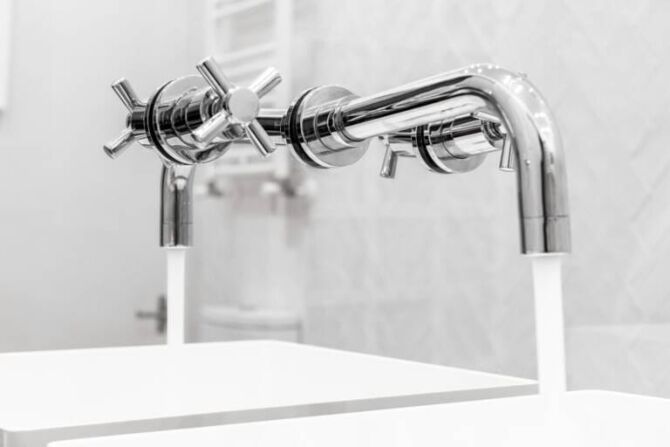 Close-up of modern chrome wall tapware installed above twin sinks in a bathroom