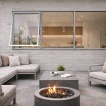 renovated outdoor living area with silver window replacement open to a contemporary kitchen interior, featuring patio seating, fire pit, and landscaped surroundings.