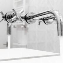 Close-up of modern chrome wall tapware installed above twin sinks in a bathroom
