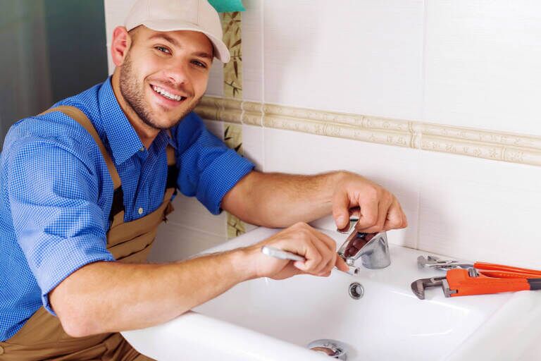 man installing a basin mixer tap